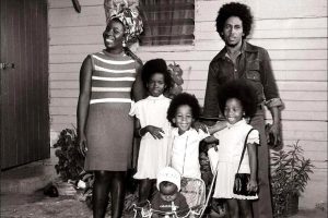 Bob and Rita Marley pose in front of their home with their kids