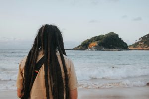 Rasta man with dreadlocks looking out over the ocean